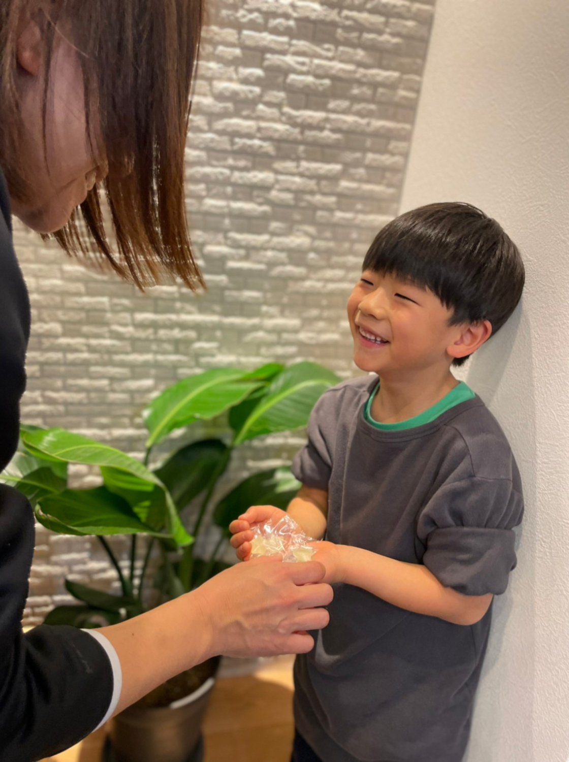 お母さんからはぐグミをもらう子どもの画像